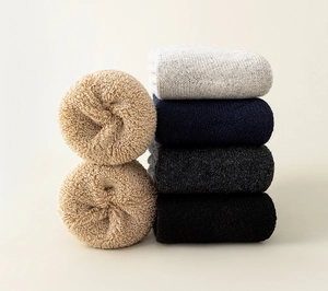 Close-up of five thick wool socks in neutral tones showing soft inner loop texture