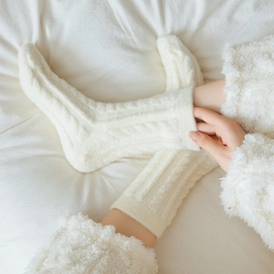 Close-up of cream cable-knit thermal socks with thick plush texture for winter warmth