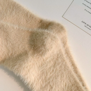 Dettaglio calzini in velluto di visone beige con morbida consistenza felpata
