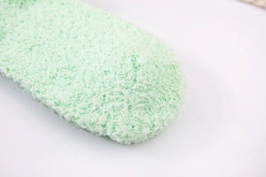 Close-up of thick mint green coral fleece socks showing fluffy texture and toe detail