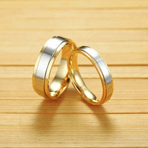 Close-up of dual-tone polished stainless steel rings with gold and silver bands