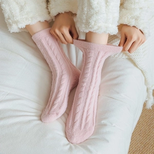 Close-up of pink cable knit fuzzy socks with thick plush lining for winter comfort