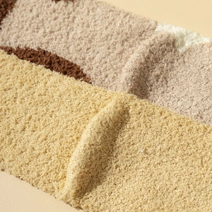 Detailed close-up of fluffy striped coral fleece fabric on cat claw socks