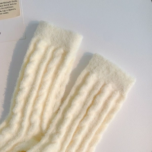 Detailed macro view of cream ribbed knit socks with warm fleece texture for winter