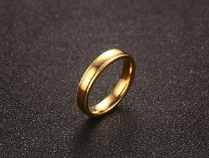 Vue macro d'une bague de 4mm en acier plaqué or avec des bords moletés élégants