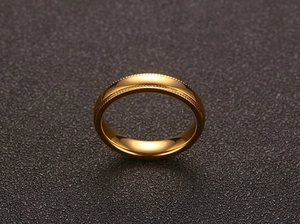 Vue macro d'une bague de 4mm en acier doré avec détails de texture gaufrée double couche