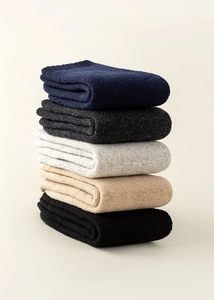 Detailed stack of five pairs of thick wool knit socks in assorted neutral winter colors