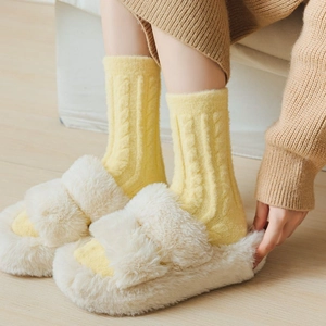 Plush off-white slippers and bright yellow cable knit thermal socks for winter