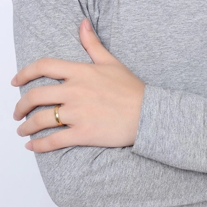 Bague minimaliste en acier inoxydable doré 4mm portée sur le doigt d'un mannequin
