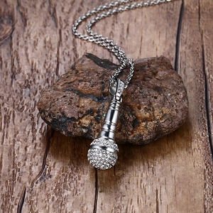 Gros plan d'un pendentif micro argenté avec strass brillants sur une pierre rustique