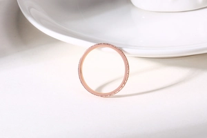 Detail of rose gold minimalist ring featuring micro-pave setting with tiny sparkling zircon stones