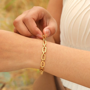 Close-up of a 18K gold-plated flat link chain bracelet worn on a wrist with adjustable clasp