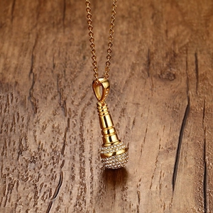 Vue détaillée du pendentif microphone doré serti de micro-strass brillants pour hommes