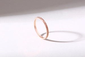 Detail of rose gold minimalist ring featuring fine frosted texture and sharp shadow