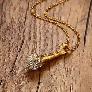 Détail macro du pendentif micro doré orné de cristaux sur un fond en bois rustique