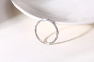 Close-up of a slim silver ring with textured frosted finish on a white background