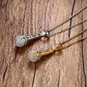 Détail de pendentifs microphone or et argent avec sertissage de strass scintillants