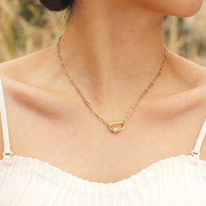 Golden paperclip chain necklace with a zircon-encrusted carabiner lock pendant on a model