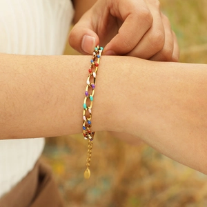 Detailed macro of 18K gold-plated chain bracelet with vibrant colorful enamel droplets