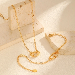Close-up of 18K gold paperclip chain necklace and bracelet set with zircon padlock charm