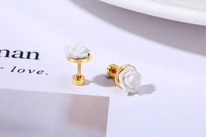 Macro detail of 3D white rose flower earrings with elegant gold-plated steel backing