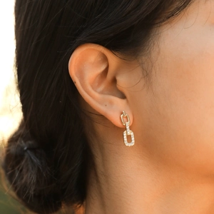 Elegant gold chain earrings with rectangular zircon link drops shown on model