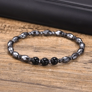 Macro detail of hematite beads with geometric facets and black agate stones on a bracelet