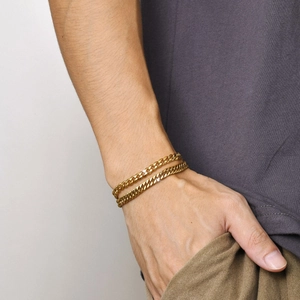 Ensemble de deux bracelets gourmette dorés pour homme et femme sur poignet
