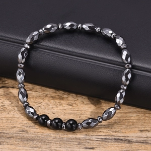 Macro shot of gray faceted hematite beads and black polished round stones on leather
