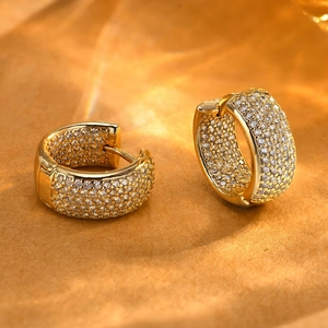 Golden C-shaped hoop earrings with sparkling zircon inlay shown in soft lighting