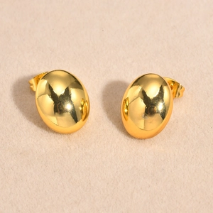 Boucles d'oreilles ovales en acier inoxydable doré poli sur fond textile beige