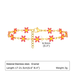Detalle de pulsera de acero dorado con flores de esmalte rosa y cierre de mosquetón