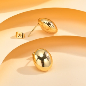 Gros plan de boucles d'oreilles ovales dorées avec finition miroir et fermoirs papillon