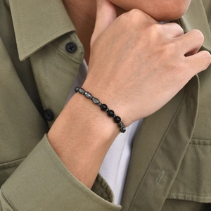 Close-up of men's beaded bracelet with black agate and faceted hematite beads on wrist