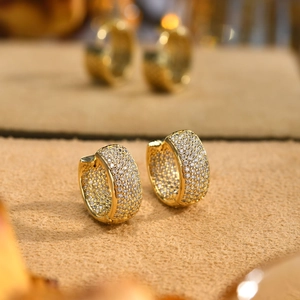 Macro detail of gold-plated hoop earrings with micro-paved sparkling zircon stones