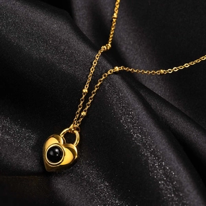 Collier cœur en acier doré avec pendentif onyx noir sur fond de soie luxueux