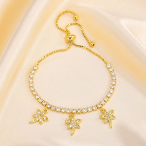 Detail of gold-plated bracelet featuring cubic zirconia and delicate dragonfly charms