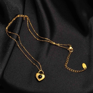 Collier cœur doré avec incrustation d'onyx sur un fond élégant en soie noire