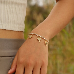 Detail of a gold dragonfly bracelet featuring sparkling cubic zirconia on a female wrist