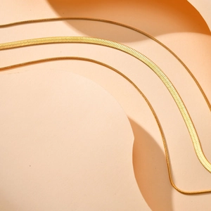 Détail d'un collier triple épaisseur en plaqué or 18K avec mailles serpent