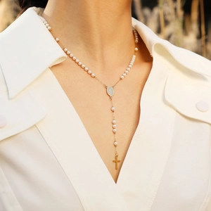 Detailansicht der goldfarbenen Rosenkranz-Kette mit Madonna-Anhänger am Model