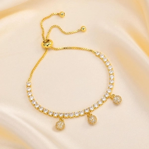 Detail of adjustable gold-tone tennis bracelet with sparkling zircon beads on silk
