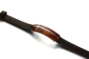 Detail of brown leather men's bracelet with wood inlay and metal cross embellishment