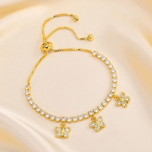 Close-up of golden tennis bracelet with butterfly pendants and adjustable slider clasp