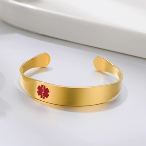 Close-up of golden medical alert cuff bracelet with red Star of Life symbol