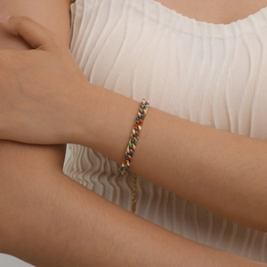 Detail of 18K gold-plated Cuban link bracelet with colorful enamel inlay on a model's wrist