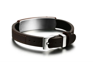 Close-up of brown leather bracelet with silver leaf village metal plate and buckle