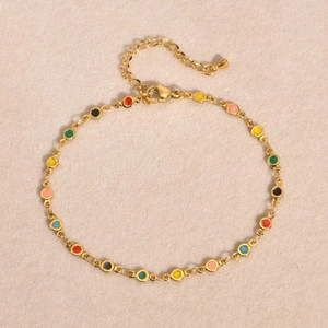 Détail de la chevillère dorée avec breloques rondes en émail coloré et fermoir mousqueton