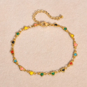 Détail d'une chevillère dorée avec breloques cœurs colorés en émail et fermoir mousqueton