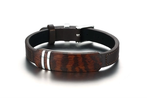 Macro detail of men's brown leather bracelet with rosewood inlay and metal accents